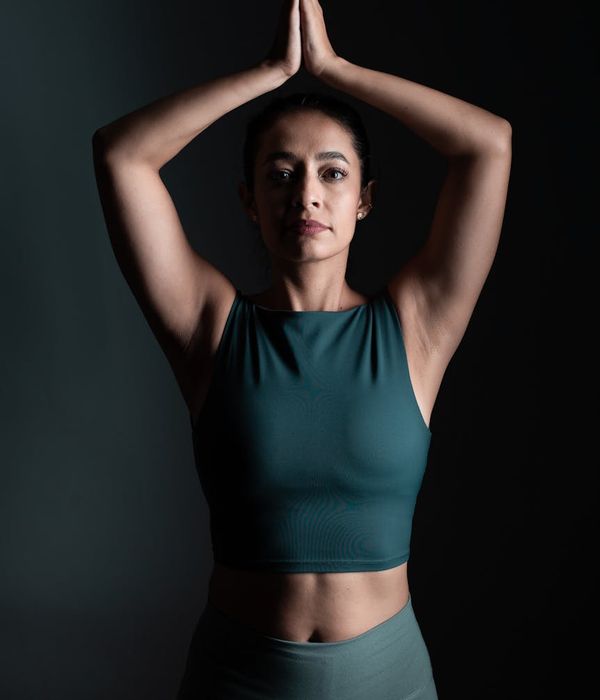 Woman in a calm yoga pose in a studio with soft lighting.
